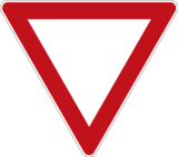 Verkehrszeichen 205 „Vorfahrt gewähren“: nach unten gerichtetes Dreieck mit rotem Rand und weißen Grund.