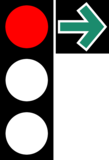 Ampel mit einem roten Licht und einem grünen Pfeil nach rechts auf schwarzem Quadrat.
